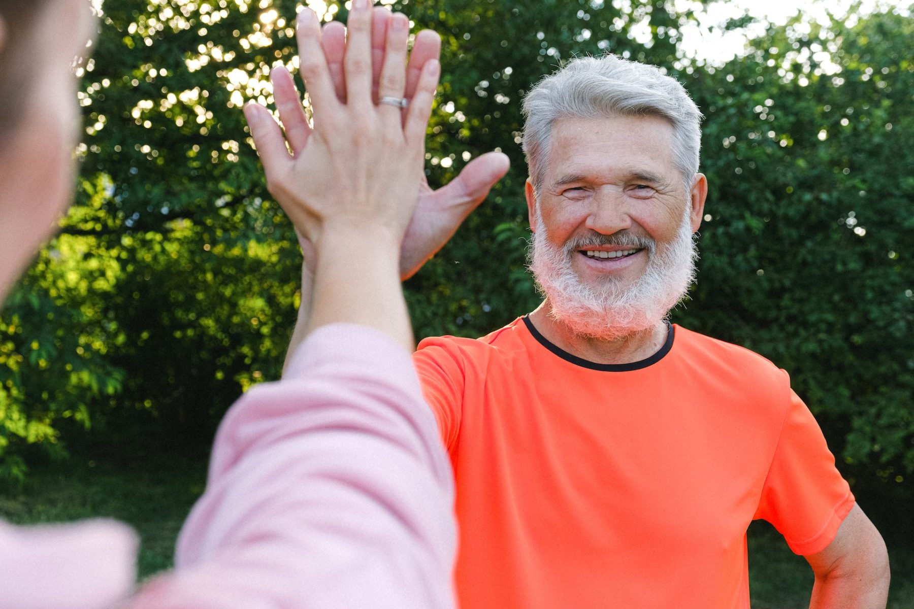 Senior, der sich engagiert schlägt glücklich zum High Five ein.